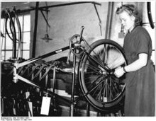"Die Jugenaktivisten Herta Schwarz beim Montieren von Fahrrädern. Sie erfüllte ihre Tagesnorm um 30% und will ihre Leistungen weiterhin steigern." (März 1951)
