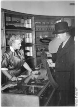 "Am 8.10.1953 eröffnete das Kaufhaus der Handelsorganisation am Alexanderplatz in der Littenstrasse einen Laden für Autos, Motor- und Fahrräder. Auch Ersatzteile sind hier erhältlich. Kollegin Sommer verkauft einen Fahrradschlauch." (Oktober 1953)