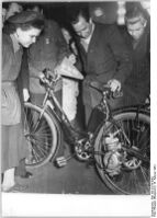 "Auf der Delegiertenkonferenz der Sozialistischen Einheitspartei Deutschlands des Kreises Magdeburg - Südost überreichten Kollegen des volkseigenen Meßgeräte- und Armaturenwerkes "Karl Marx" der neuen Kreisleitung den ersten Fahrradhilfsmotor, Sie haben sich verpflichtet, 1954 9 500 Sück davon herzustellen. Der Fahrradhilfsmotor findet bei den Delegierten grosses Interesse." (Februar 1954)