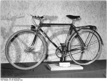 "[...] ein modernes Tourenrad, welches bereits nach dem neuen Verfahren hergestellt wurde und sich noch in der Erprobung befindet." Über dieses Fahrradmodell, das offenbar auch in seiner Ausstattung ein Prototyp war, ist nichts weiter bekannt. Bei der Ausstattung sind vor allem die Hochflanschnaben sowie das Doppelkettenblatt bemerkenswert. (Dezember 1956)