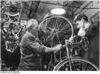 "In der Rennabteilung des VEB Rahrradwerkes Elite-Diamant in Karl-Marx-Stadt. Fahrradmonteur Fritz Bockwitz (links) gilt schon seit 40 Jahren als Experte auf dem Gebiet der Montage von Rennrädern." (1958)