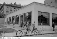 "Passanten betrachten die Schaufenster des Fahrradgeschäftes "Preisser" an der Gabelsbergerstraße." (1954)