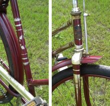 Vorstehendes Fahrrad - Details des Spritzdekors an Sattelrohr und Steuerkopf. Das Steuerkopfschild wurde hier nicht, wie bei vielen Werkstätten zumeist üblich, überlackiert, sondern vor der Lackierung entfernt und anschließend mit neuen Nieten (aus Aluminium) wieder befestigt.