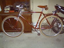 Dieses Exemplar von 1956 ist bereits mit einem Flachlenker und einer Stempelbremse mit Bowdenzug ausgestattet. Gegenüber dem zwei Jahre älteren Fahrrad fällt außerdem der vereinfachte Strahlenkopf auf.