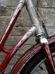 Zeitraum: 1956-1960 Zu finden an: Tourenrädern und Tourensporträdern Beschreibung: Strahlenkopf (einfacher Strahl an der Gabel; silber mit farbigen Spitzen)