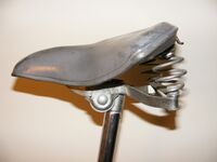 Tourensattel von Möve Zeitraum: spätestens 1972 bis 1990 Verwendung: Touren-, Tourensport- und Klappräder Decke: Gummi Gestell: Stahl, verchromt oder verzinkt Bemerkungen: Ausführungen für Damen- und Herrenräder ("Modell P 400"). Mit Halter für Satteltasche.