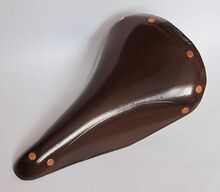 Rennsattel Nr. 466 VL (Möve) Zeitraum: 1954 bis 1955 Lederdecke: schokoladenbraun lackiert Gestell: verchromt Bemerkungen: Plakette mit fliegender Möwe, geprägte Linie in den Flanken