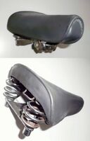 Terrysattel von Möve Zeitraum: 1970 bis 1990 Verwendung: Klappräder Decke: Gummi Gestell: Stahl, verchromt oder verzinkt Bemerkungen: mit Halter für Satteltasche