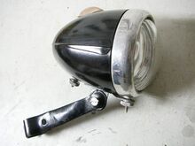 Scheinwerfer MGK 310a Zeitraum: ca. 1955 bis 1957 Verwendung: Zubehör Material: Duroplast, Aluminium, Glas Ø Lichtaustritt: 66 mm