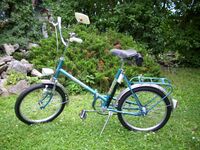 Referenz-Fahrrad (?) ============== Das hier gezeigte Klappfahrrad aus dem Jahre 1977 befindet sich vollständig im Originalzustand. Der Seitenständer sowie der Rückspiegel (zeitgenössisches Fahrradzubehör) wurden nachträglich angebracht.