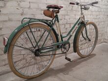 Das Fahrrad ist weitgehend original erhalten, es fehlt das Kleidernetz. Lenker und Sattel sind auch an diesem 26"-Fahrrad kleiner bzw. schmaler gehalten als an Rädern für Erwachsene.