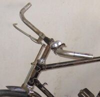 Im Gegensatz zu den Tourenradlenkern jener Zeit ist dieser Mifa Sportradlenker von 1953 insgesamt etwas weniger geschwungen und die Lenkerenden sind leicht aufwärts geneigt. Ein Unikum für Sporträder ist die Gestängebremse statt der sonst üblichen Bowdenzugstoßbremse oder, je nach Ausstattung, der Felgenbremse.