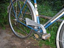 Der Aluminium-Kettenschutz war typisch für die Luxus-Sporträder. Die dafür notwendigen Halterungen waren am Sattel- bzw. Unterrohr angelötet, letztere diente gleichzeitig als Führungsöse für den Bowdenzug.