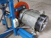 Lichtmaschinenbremse; links im Bild der Hochlastwiderstand, der durch Luft- schaufeln an der Schwungscheibe (orange) gekühlt wird