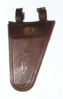 Zeitraum: vrmtl. Anfang 1950er Jahre Hersteller: ?? Material: vrmtl. PVC Bekannte Farben: Dunkelbraun Verwendung: Zubehörteil Bemerkungen: Betriebsnummer im Inneren. Aus zwei Stücken gefertigt. Nähte nur imitiert.