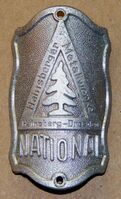 "National"-Steuerkopfschild, ab etwa 1937 bis mindestens zur Rahmennummer 533.684, Material: Aluminium, massiver Guss. Originale Farbgebung in Rot-Grün wie rechts nebenstehend.