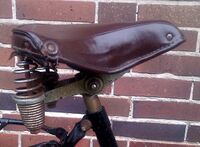 Tourensattel von ?? Zeitraum: 195? bis 1957 Verwendung: Simson-Fahrräder Decke: Kunstleder Gestell: Stahl, verchromt Bemerkungen: Ausführungen für Damen- und Herrenräder, Regulierfedern, mit Simson-Plakette an der Rückseite, Hersteller unbekannt