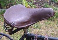 Tourensattel von ?? Zeitraum: 195? bis 1957 Verwendung: Simson-Fahrräder Decke: Kunstleder Gestell: Stahl, verchromt Bemerkungen: Ausführungen für Damen- und Herrenräder, mit Simson-Plakette an der Rückseite, Hersteller unbekannt