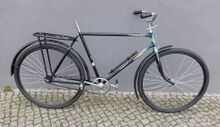 Von Urania Anfang/Mitte der 1950er Jahre professionell aufgearbeitetes Fahrrad. Es handelt sich offensichtlich um ein Vorkriegsrad, die Vorderradgabel stammt von Simson. Das Fahrrad hatte vor der Aufarbeitung offensichtlich einen Unfall (leicht gestauchtes Oberrohr hinter der Steuerkopfmuffe). Es wurde die Gabel ersetzt und...